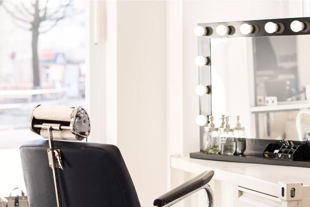 Ein Friseurstuhl mit Spiegel am Fenster