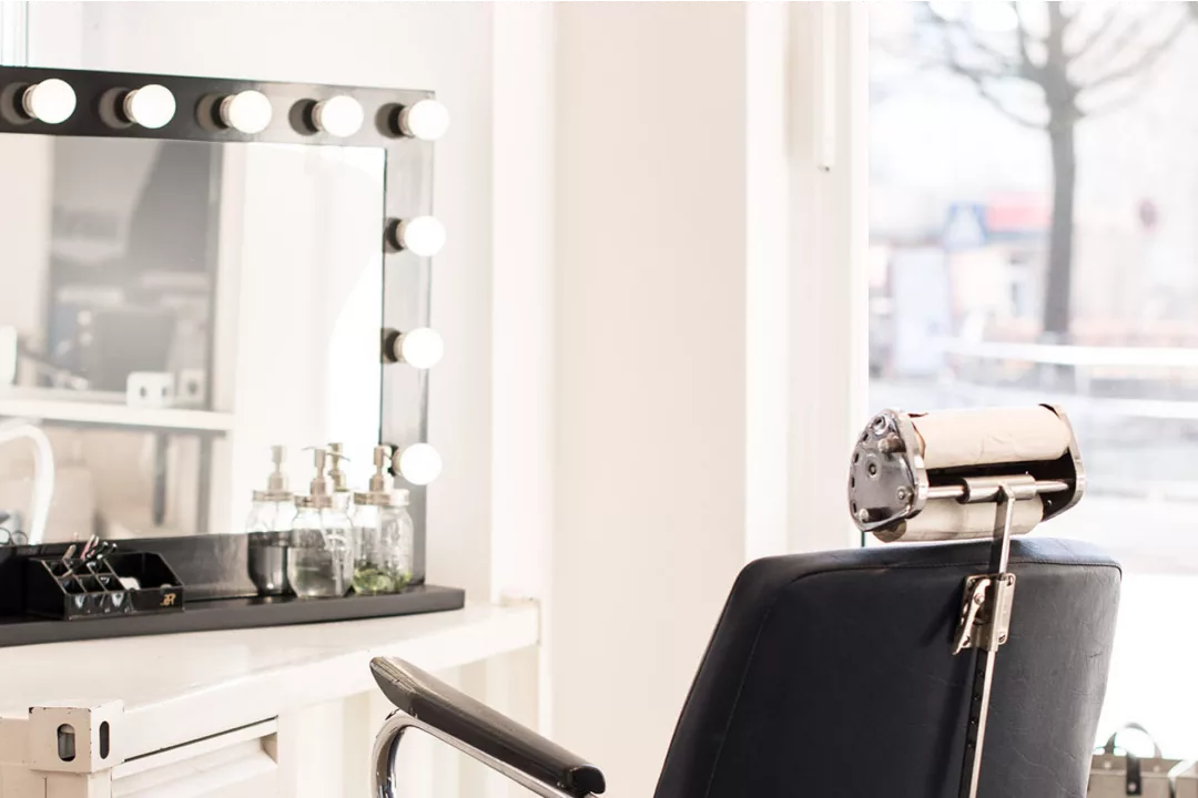 Ein Friseurstuhl mit Spiegel am Fenster