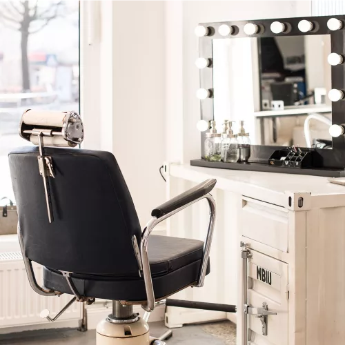 Ein Friseurstuhl mit Spiegel am Fenster